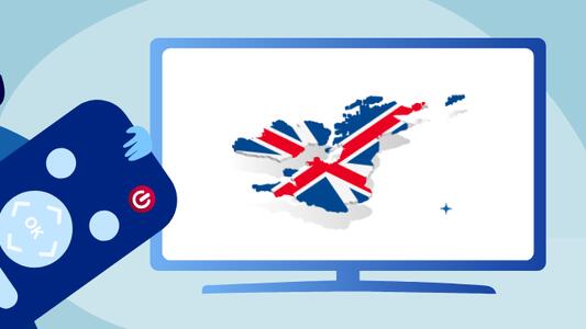 man holding a giant remote control in front of a TV screen with the british flag